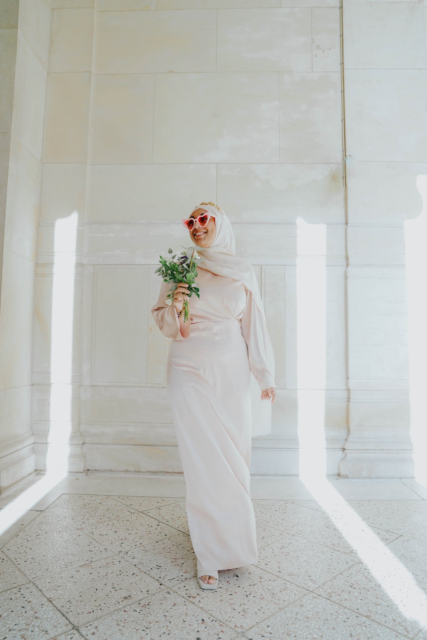 Robe en satin russe couleur nude rosé avec croisé à la taille.  Manches longues évasées