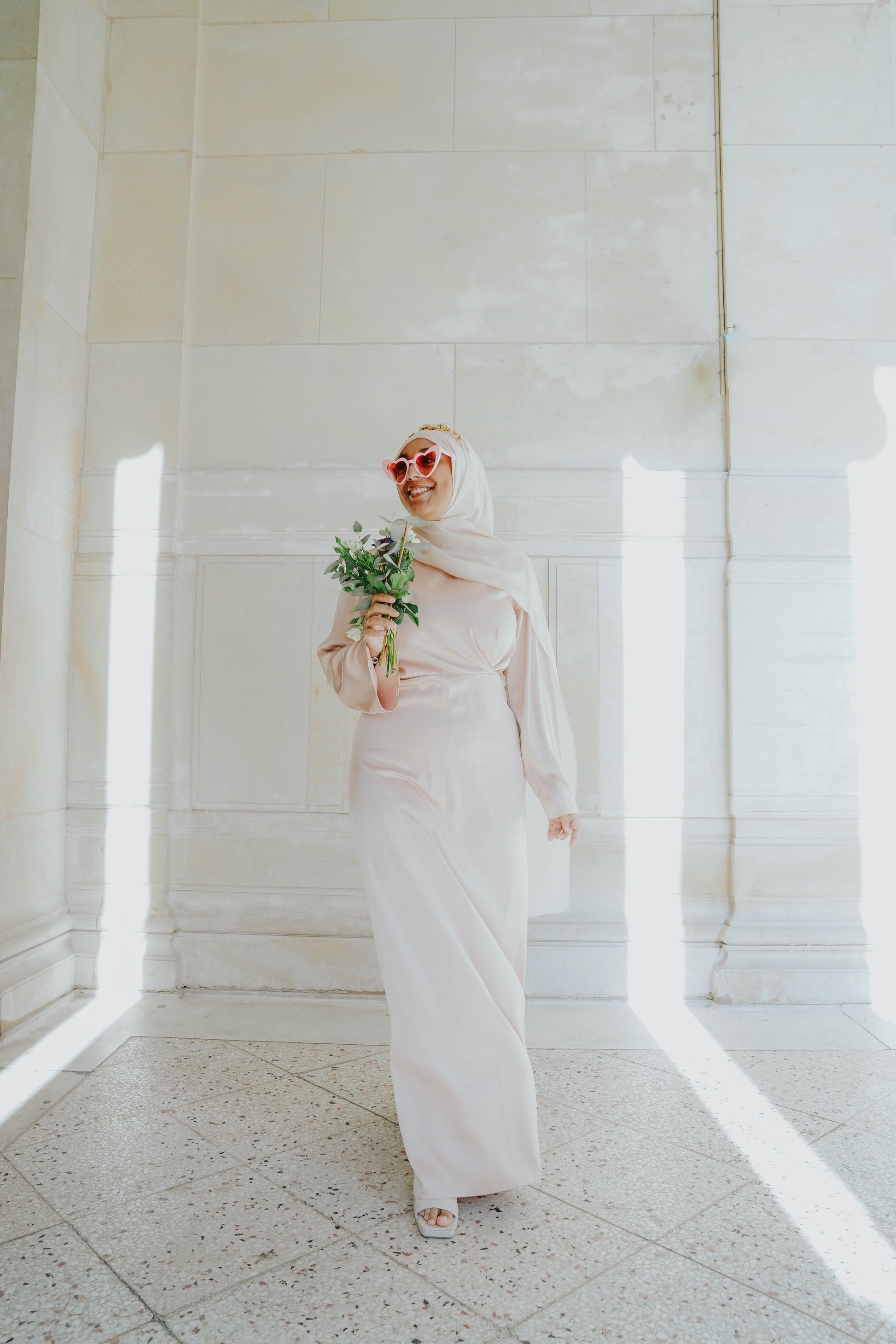 Robe en satin russe couleur nude rosé avec croisé à la taille.  Manches longues évasées