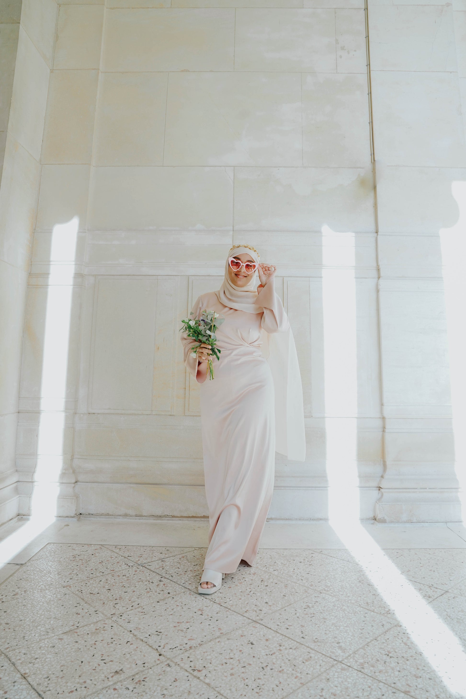 Robe en satin russe couleur nude rosé avec croisé à la taille.  Manches longues évasées