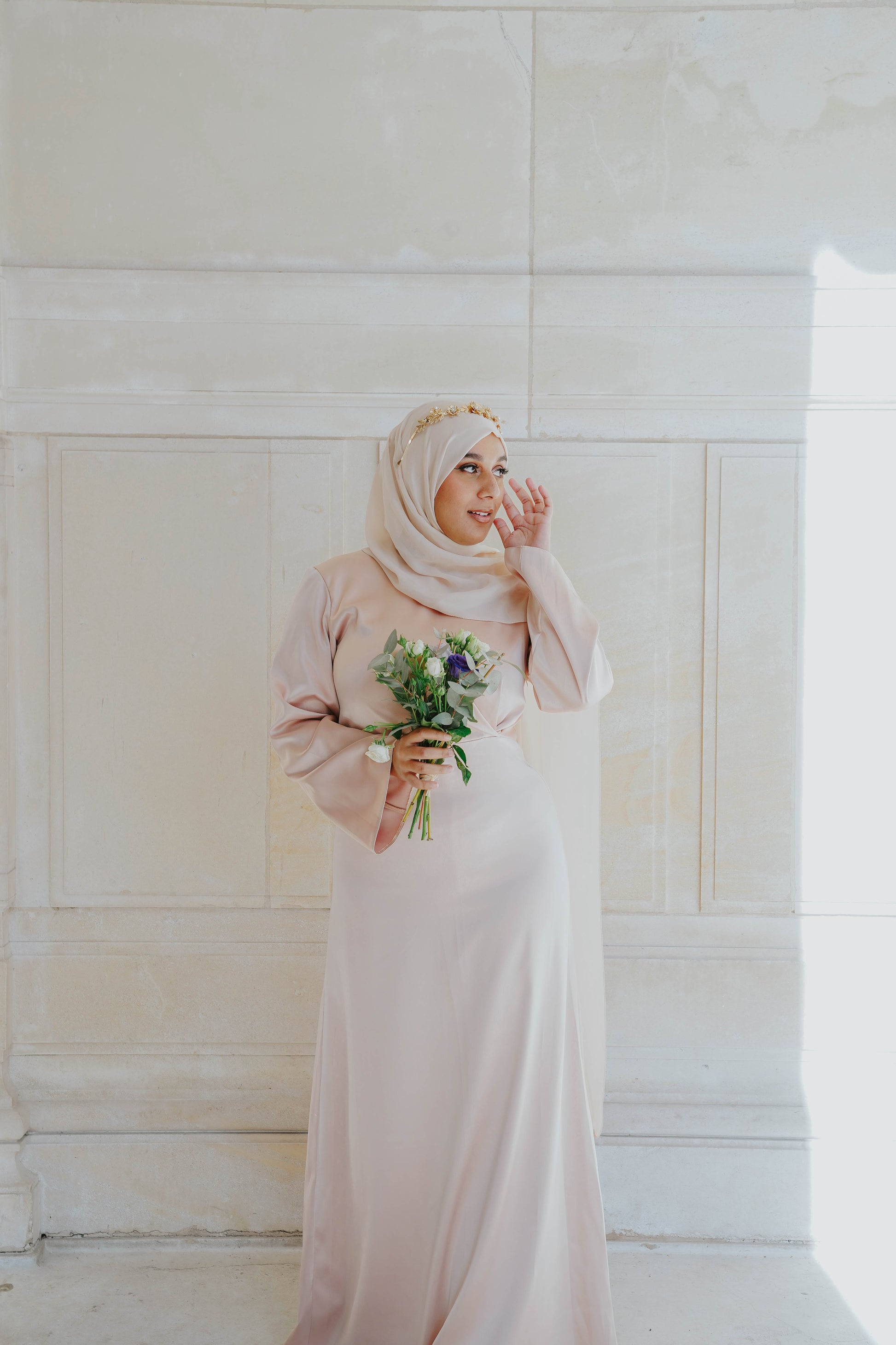 Robe en satin russe couleur nude rosé avec croisé à la taille.  Manches longues évasées