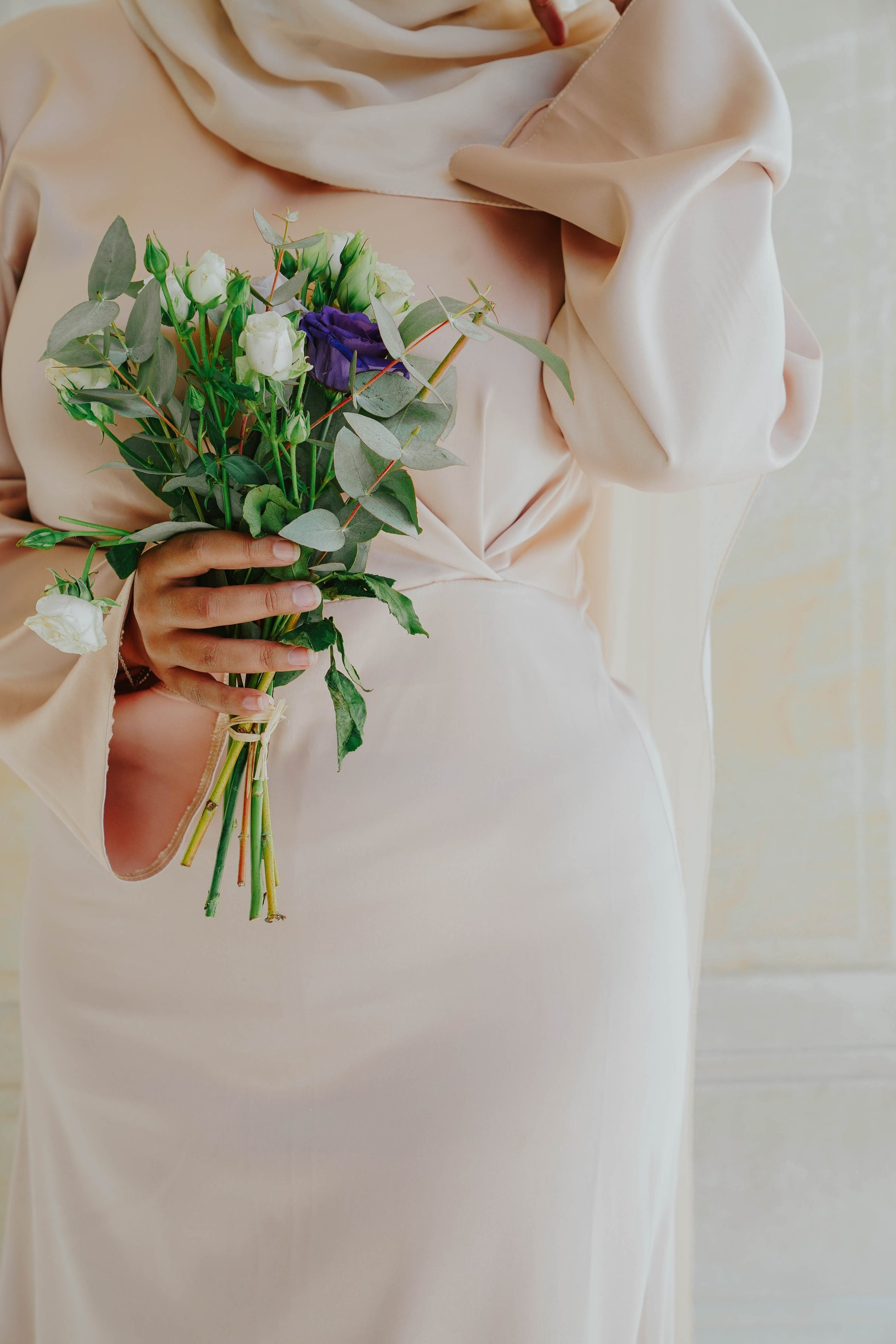 Robe en satin russe couleur nude rosé avec croisé à la taille.  Manches longues évasées